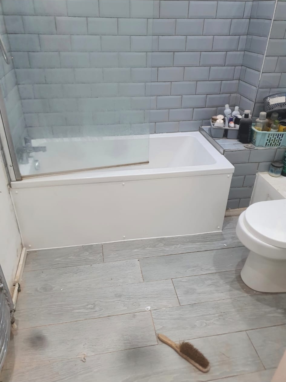 New bath installation with blue subway tiling and glass shower screen, bathroom fitters, South East London.