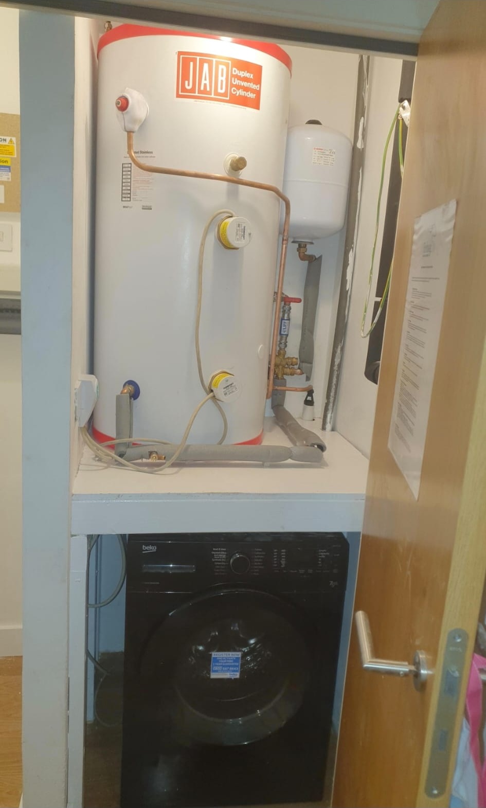 Unvented hot water cylinder installed above utility appliances: G3 qualified installation, London.